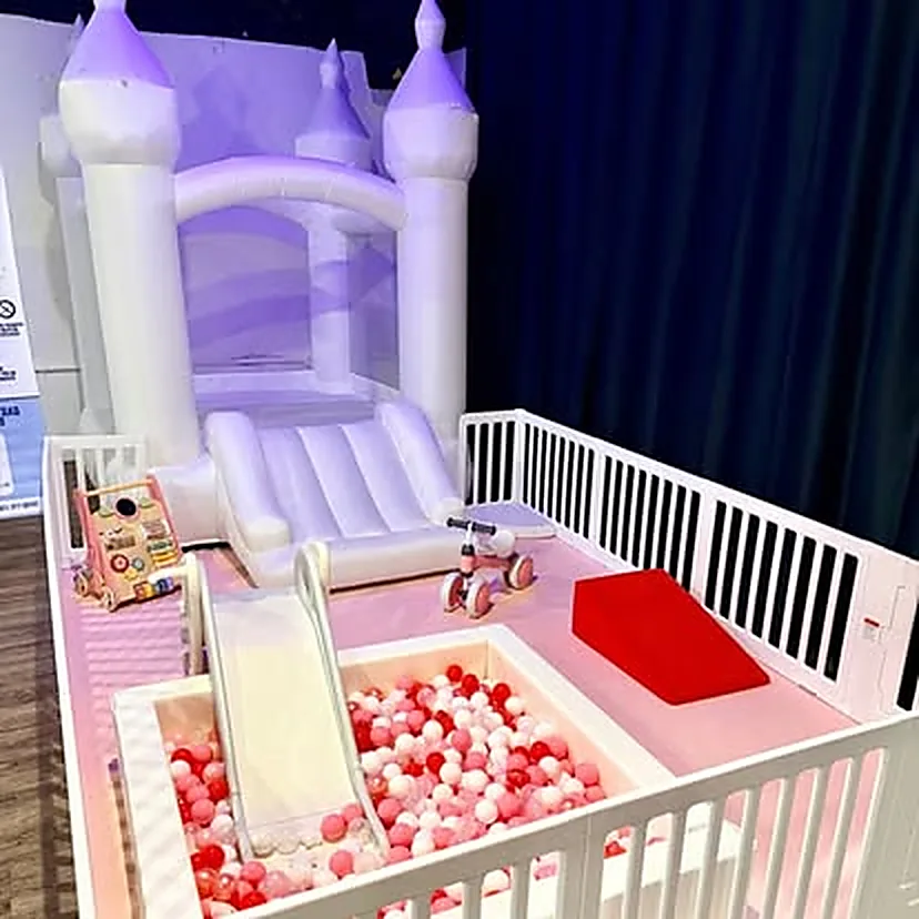 Castillo inflable lila con tobogán y piscina de pelotas rosa