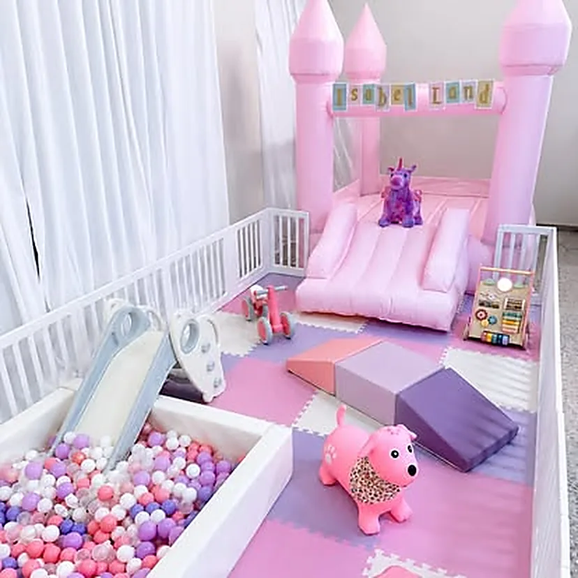 Castillo inflable rosa con un banner que dice Isabel Land sobre las torres