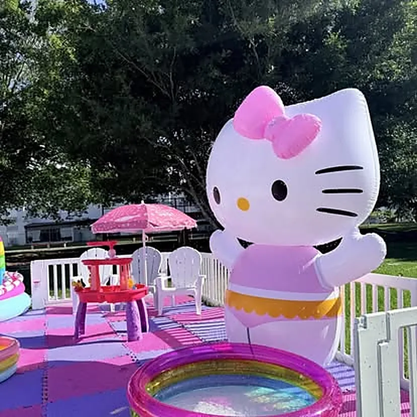 Inflable gigante de gatita rosa con mesa y sillas infantiles, sombrilla y piscina pequeña