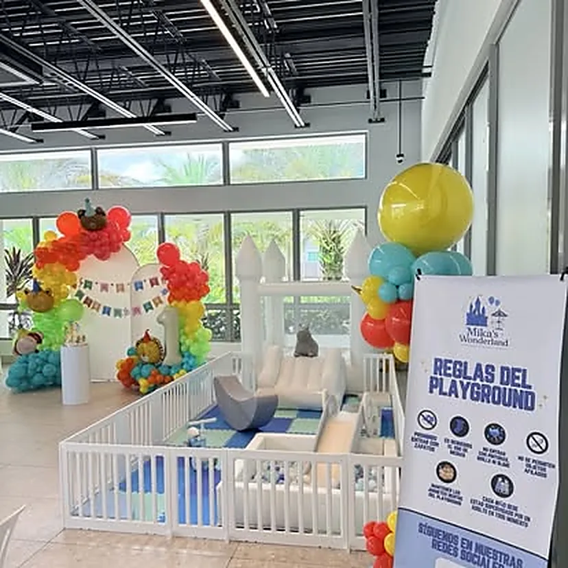 Playground montado dentro de un salón de eventos con arco de globos